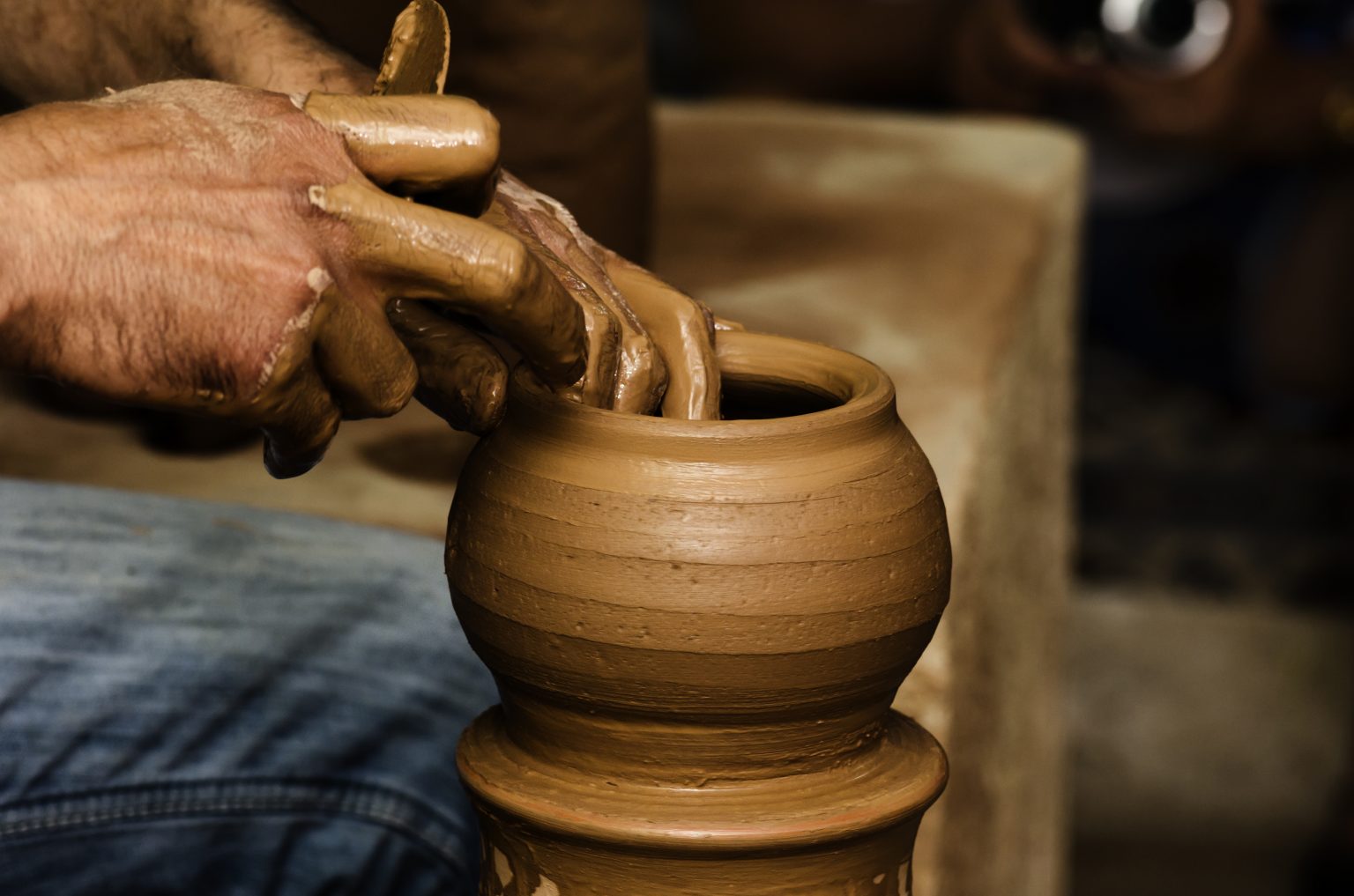 Potter shaping clay on the pottery wheel